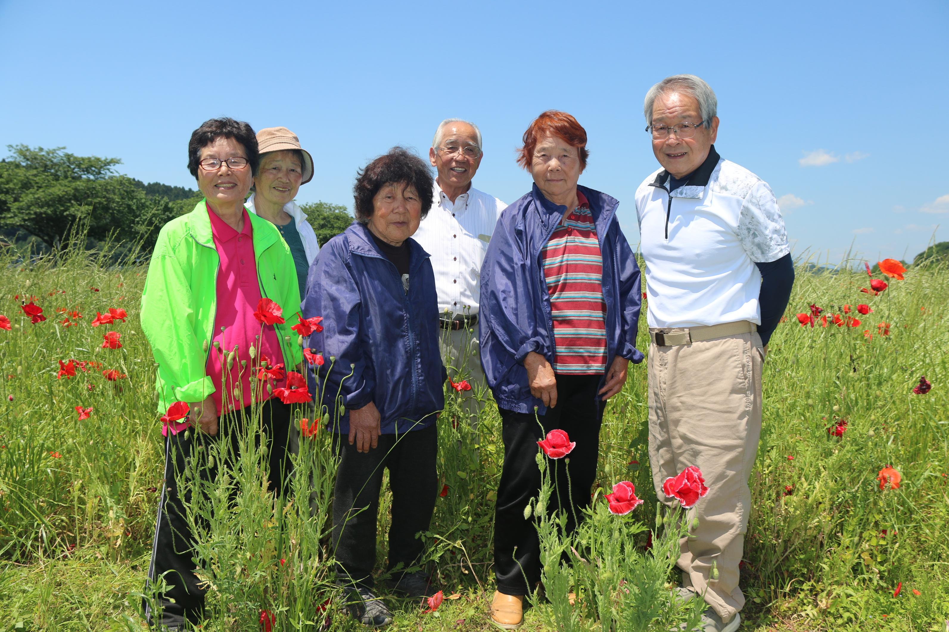 ポピー畑にいるボランティアの方々の写真